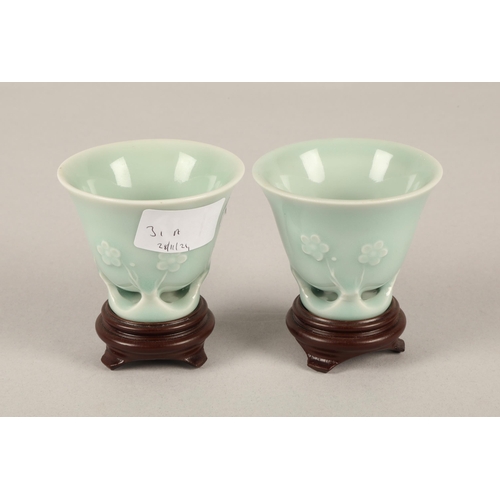 31A - Pair of Oriental celadon glaze ceramic cups on on wooden stands...