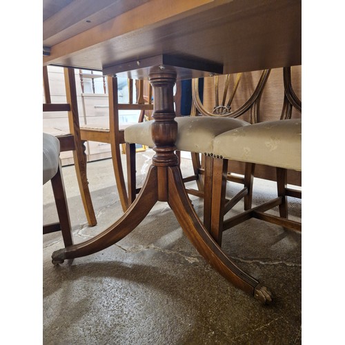 667 - Mahogany dining table on two pedestals with brass claw feet and casters, with six side chairs and tw... 