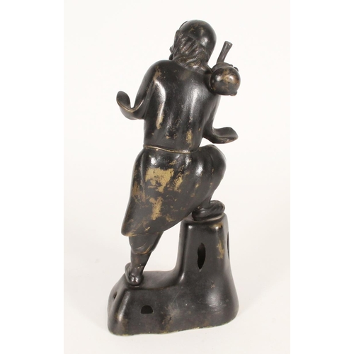 377 - Chinese bronze statue of a travelling monk, with shouldered gourd and on stepped base, H26cm.