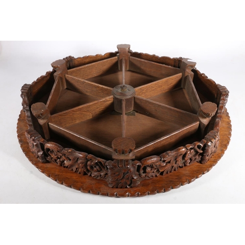 300 - Victorian carved oak revolving Lazy Susan, the plain top with central Welsh dragon, acorn and oak le... 