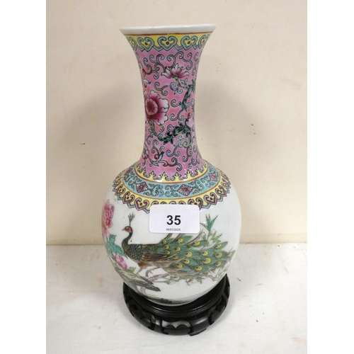 35 - Modern Famille Rose bottle vase decorated with a peacock.25cm high