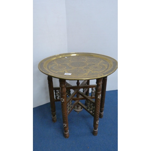 510 - Arabic brass charger with steel and copper inlays, on folding table base, 54cm diameter.