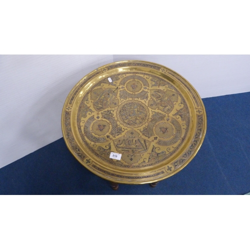 510 - Arabic brass charger with steel and copper inlays, on folding table base, 54cm diameter.