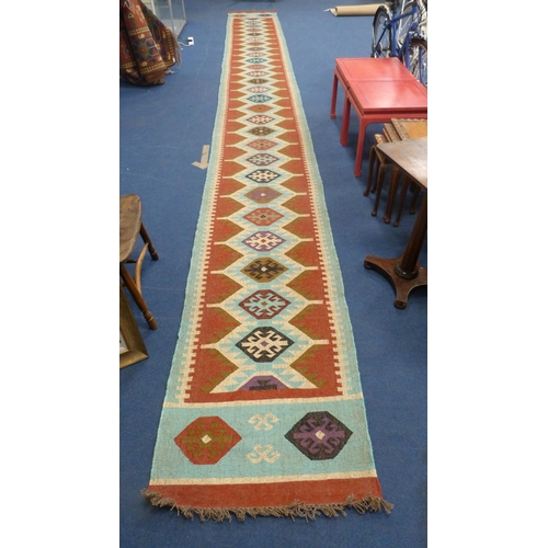 513 - Large Turkish woven hall runner with repeating gul pattern, 730cm x 80cm.