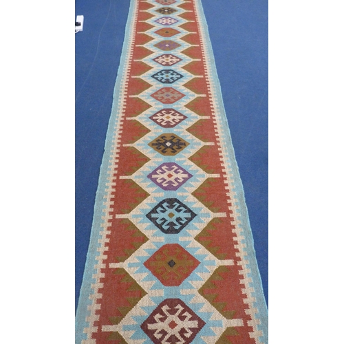 513 - Large Turkish woven hall runner with repeating gul pattern, 730cm x 80cm.