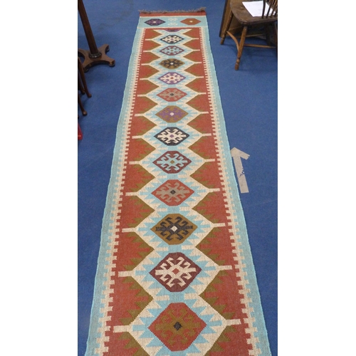 513 - Large Turkish woven hall runner with repeating gul pattern, 730cm x 80cm.