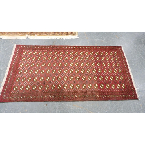 516 - Turkoman-style red ground rug decorated with six rows of guls, 193cm x 103cm.