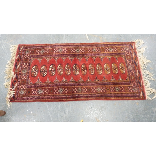 517 - Turkoman-style red ground rug with single row of guls, 150cm x 75cm.