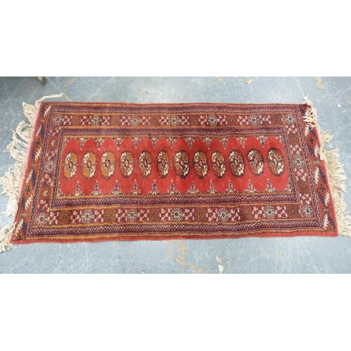 517 - Turkoman-style red ground rug with single row of guls, 150cm x 75cm.