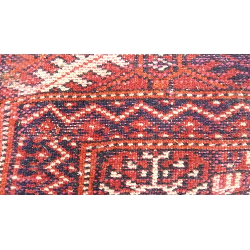 517 - Turkoman-style red ground rug with single row of guls, 150cm x 75cm.