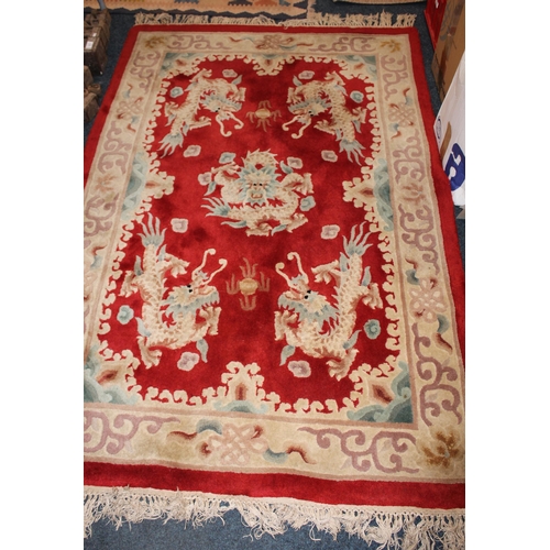 969 - Chinese red ground wash wool rug with dragon decoration.