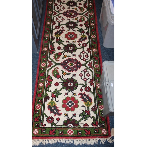 974 - Near pair of cream ground hall runners with green border and floral decoration.