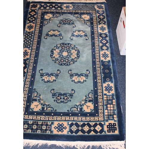 978 - Red ground multi bordered fringed rug 162cm x 110cm and  a blue Chinese wash wool rug.