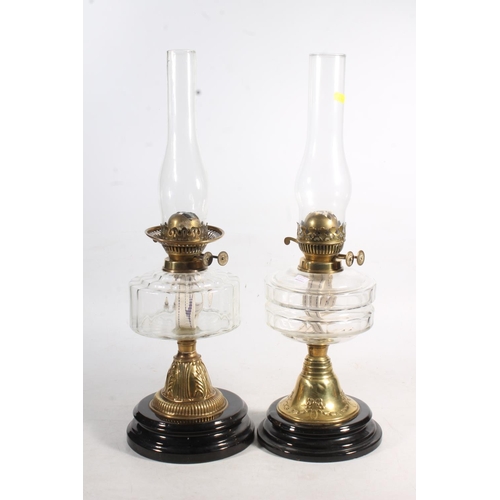 188 - Two Victorian glass oil lamps on brass columns and ebonised terracotta bases.