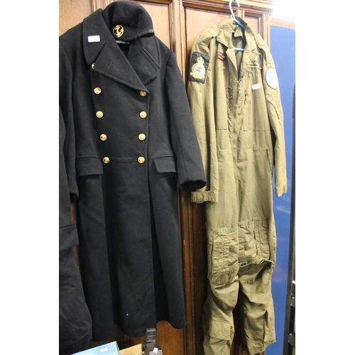 210 - British Naval black cloth long coat with brass buttons and similar cap, also a khaki flying suit.