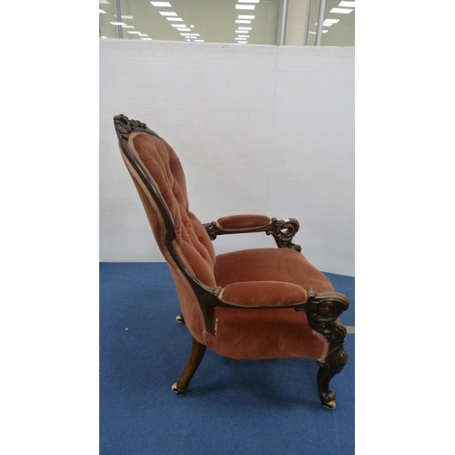 335 - Victorian button-back armchair with pink upholstery, on castors.