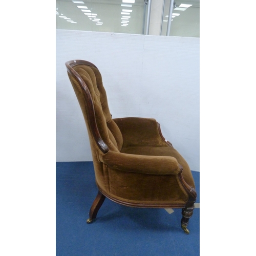 336 - Victorian button-back armchair with brown upholstery, on brass castors.