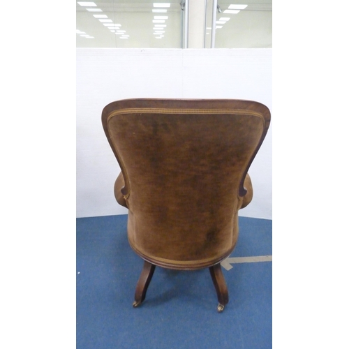 336 - Victorian button-back armchair with brown upholstery, on brass castors.