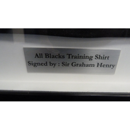 35 - Framed All Blacks rugby training shirt, signed by Sir Graham Henry.