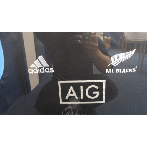 35 - Framed All Blacks rugby training shirt, signed by Sir Graham Henry.