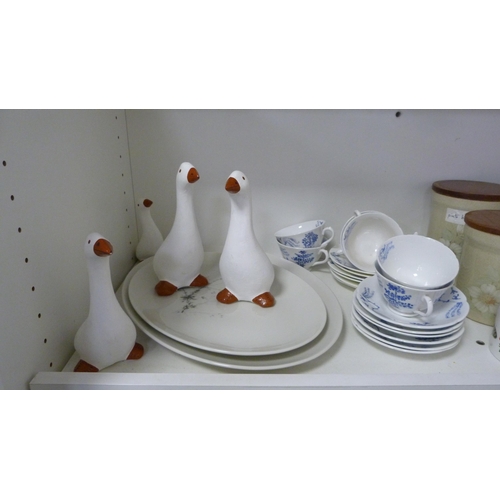 84 - Six Denby storage jars, blue decorated part tea set, four graduated ducks etc (one shelf).