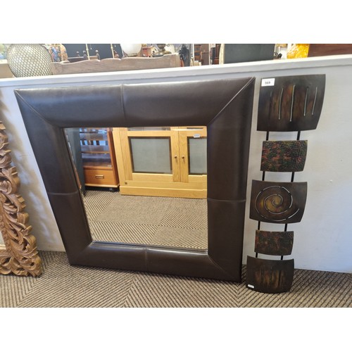 569 - Leatherette framed wall mirror with metal decorative wall art  