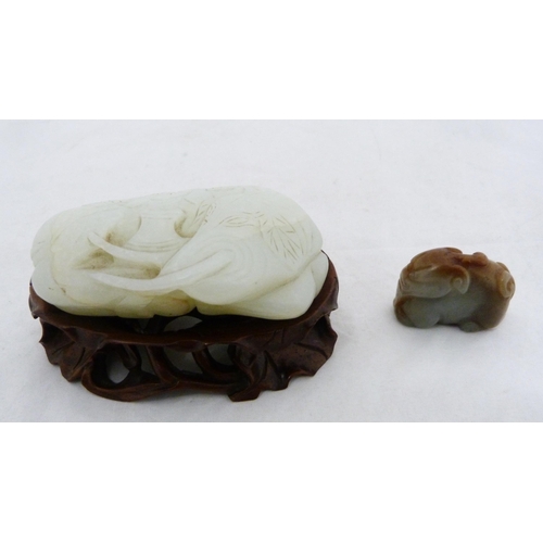 315 - Chinese celadon jade carving of a recumbent kylin, Qing Dynasty, on a padouk stand, 9cm, and another... 