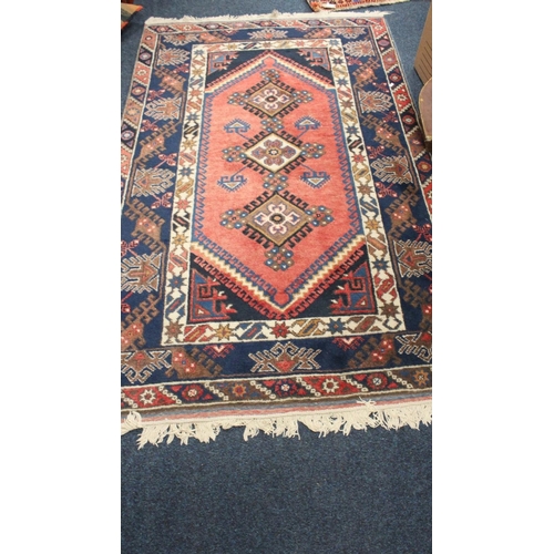 699 - Red and blue ground rug with geometric decoration, 200cm x 124cm.