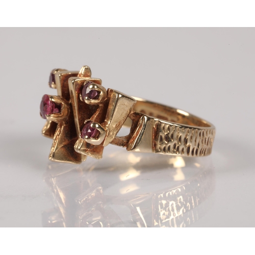 57 - 9ct gold ring in modernist design set with garnets , ring size J, 4.3g