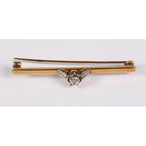 58 - Yellow metal bar brooch set with a diamond flanked by four smaller diamonds, 4.5g