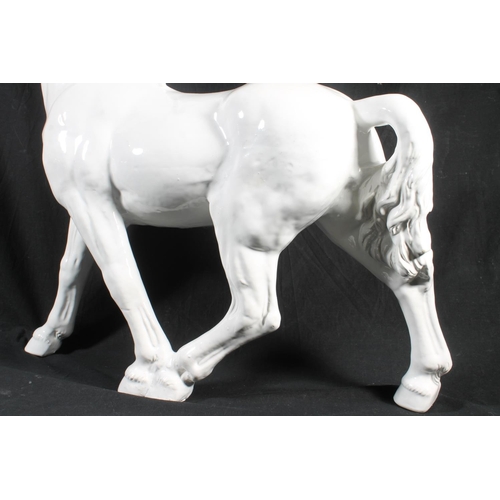 62 - White glazed ceramic model of horse, 59cm high.