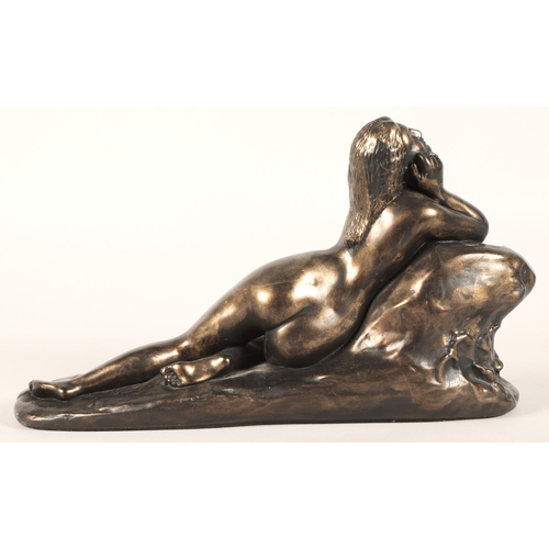 273 - Bronze statue of a lying lady leaning on a rock. 44cm long.