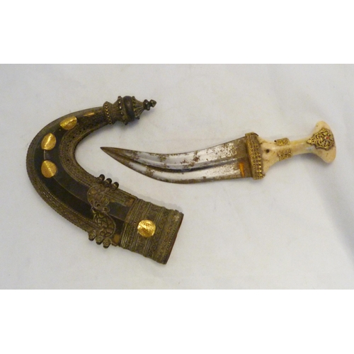 329 - Arabic Jambiya dagger, with bone hilt bearing yellow metal appliques and ruby-coloured jewelled ston... 
