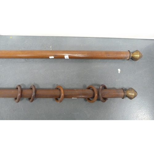 127 - Two vintage mahogany curtain poles with brass terminals.