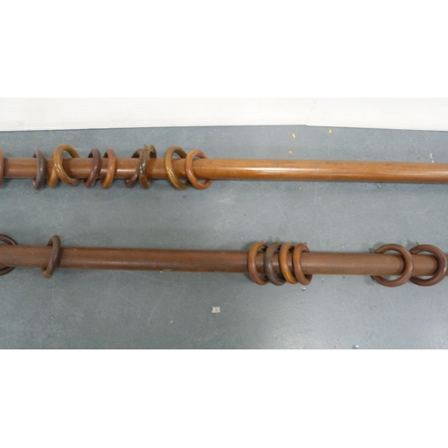 127 - Two vintage mahogany curtain poles with brass terminals.