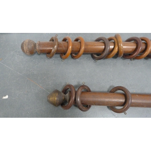 127 - Two vintage mahogany curtain poles with brass terminals.