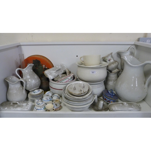 141 - Chamber pots, water jugs, soap dishes, toilet bowls, bed slipper pans, wash basins etc (three shelve... 