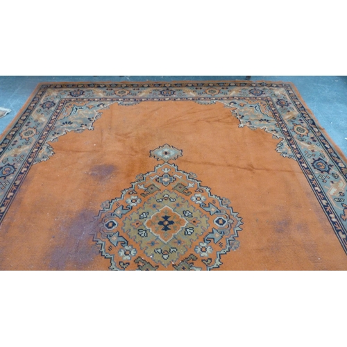 295 - Turkish wool carpet on a rust ground, with green, blue and rust border.