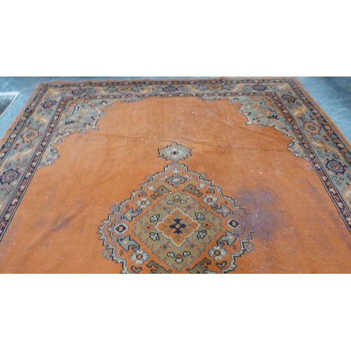 295 - Turkish wool carpet on a rust ground, with green, blue and rust border.