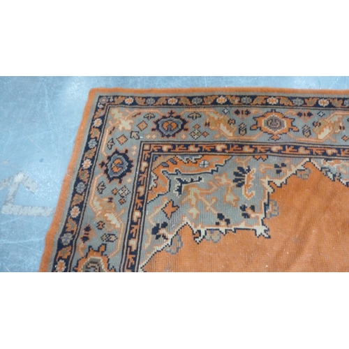 295 - Turkish wool carpet on a rust ground, with green, blue and rust border.