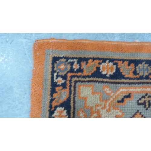 295 - Turkish wool carpet on a rust ground, with green, blue and rust border.