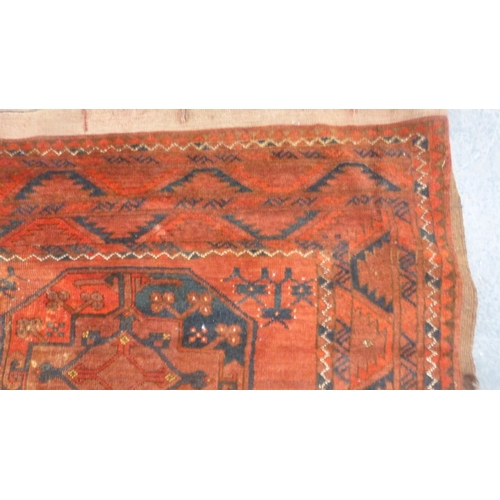 327 - Afghan-style Belouch carpet with rows of geometric medallions on a red ground.