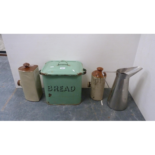 351 - Green enamel bread bin and cover, large metal kitchen jug and two stoneware pigs.  (4)