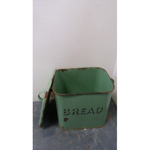 351 - Green enamel bread bin and cover, large metal kitchen jug and two stoneware pigs.  (4)