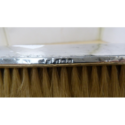 79 - Group of clothes brushes to include two silver backed brushes.