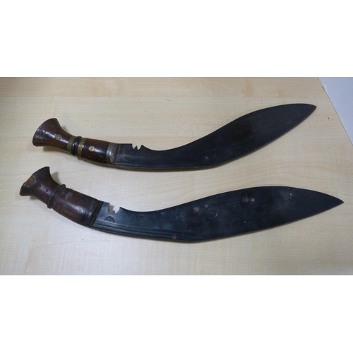 80 - Two kukri daggers with wooden grips.