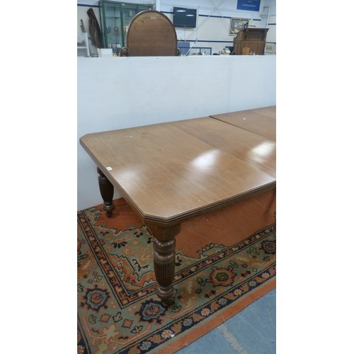 294 - Mahogany extending dining table with two additional leaves.