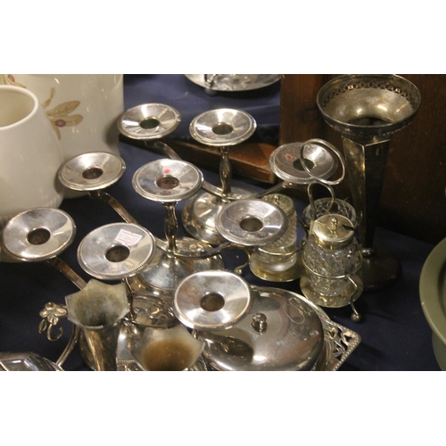 57 - Silver-plated items to include candlesticks, vases, a toastrack, etc.