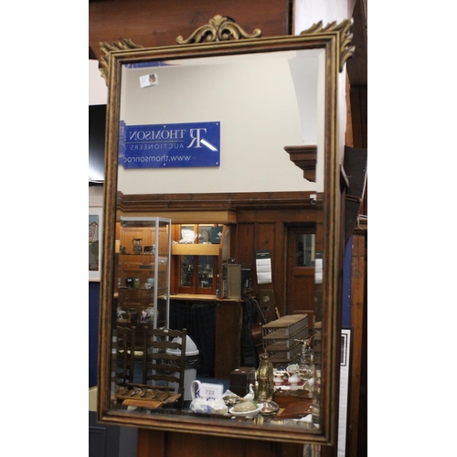 723 - Gilt framed wall mirror with floral surmount.