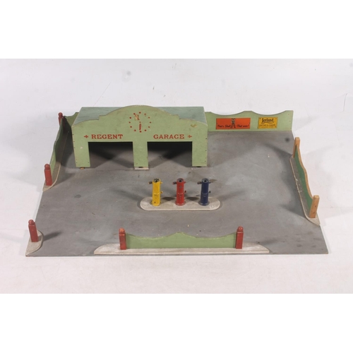 128 - Mid-20th century painted wooden model of a garage and garage forecourt, 48cm wide.